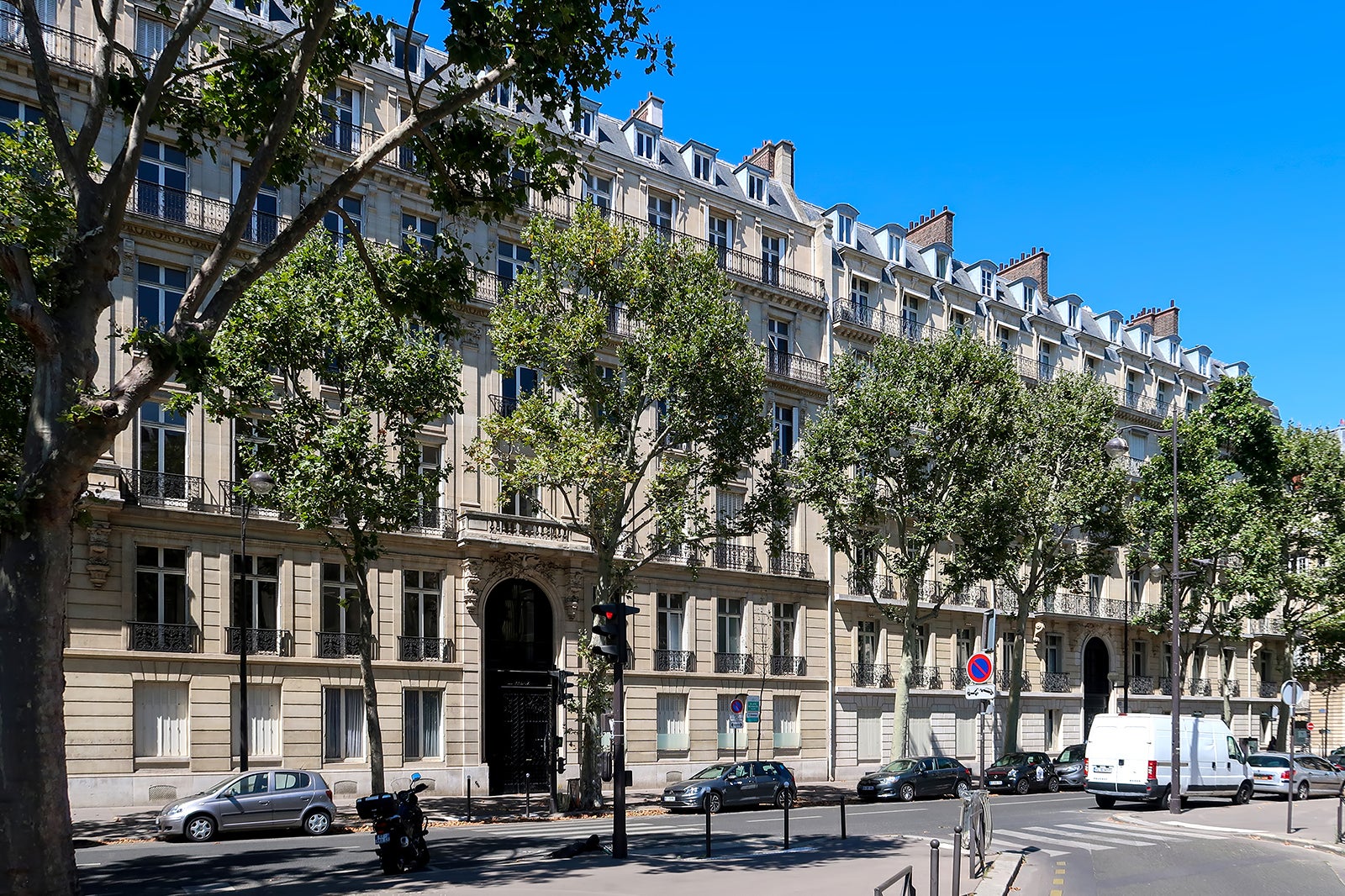 A picture of a street lined with cars in Paris.