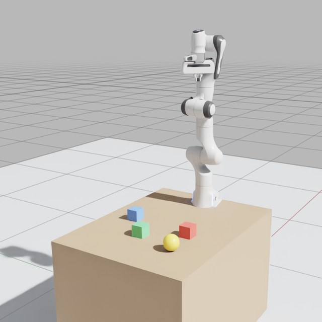 A Franka arm on a table with a red, a green and a blue block and a yellow ball, as capture_viewport returns it from Isaac Sim